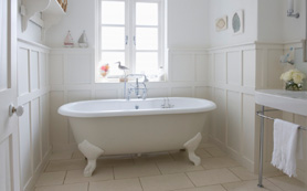 A double ended Roll Top Bath in a traditional bathroom with wooden panels